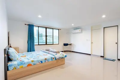 a bedroom with a bed with a blue curtain at Surawong Condominium in Bangkok