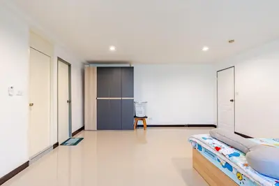 a bedroom with white walls and a bed at Surawong Condominium in Bangkok