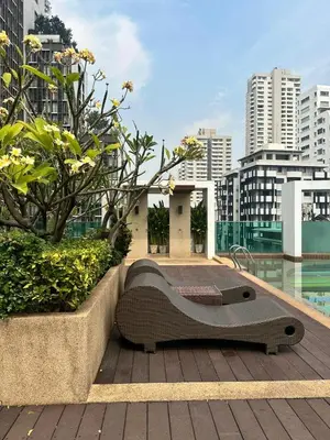 a bench sitting on a deck with a view of a city at Spacious Sukhumvit Condo near EmQuartier in Bangkok