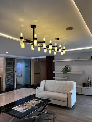 a living room with a couch and a chandelier at Spacious Sukhumvit Condo near EmQuartier in Bangkok