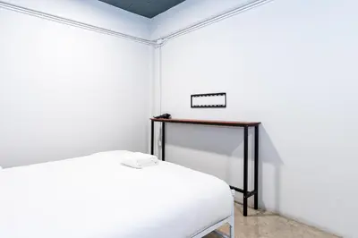 a white room with a bed and a table at xx Yellow Place Sukhumvit Soi 2 -เยลโล เพลส สุขุมวิทซอย 2 in Bangkok