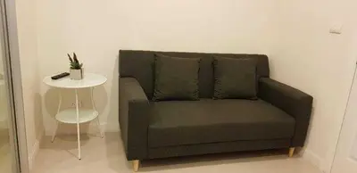 a couch in a room with a side table at Mari's space Riverview in Nonthaburi
