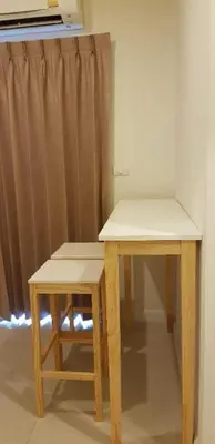 a table and stool in a room with a curtain at Mari's space Riverview in Nonthaburi
