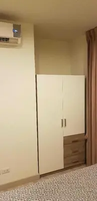 a room with a large white cabinet in a bedroom at Mari's space Riverview in Nonthaburi