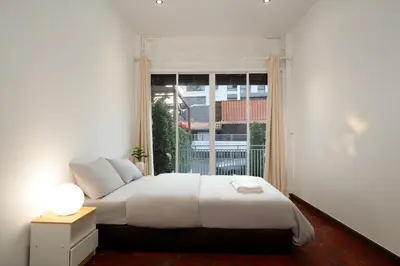 a bedroom with a bed and a large window at Designer house Chao Phraya River - OH Homes 12 in Bangkok