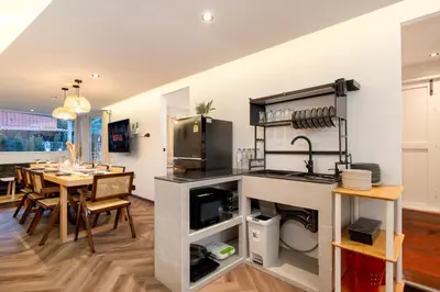a kitchen and dining room with a dining table and a kitchen gmaxwell gmaxwell at Designer house Chao Phraya River - OH Homes 12 in Bangkok