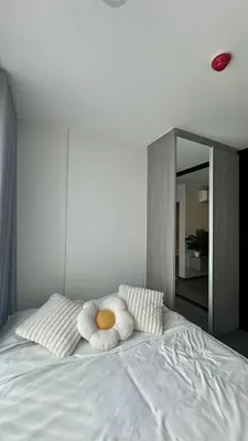 a white bed with two pillows and a mirror at 1Bed Room Near Airport BTS Big-c Swimming Pool Gym in Bang Khen