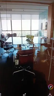 an office with a table and chairs and a large window at IDEO Wat Thaphra Bangkok Yai in Bangkok