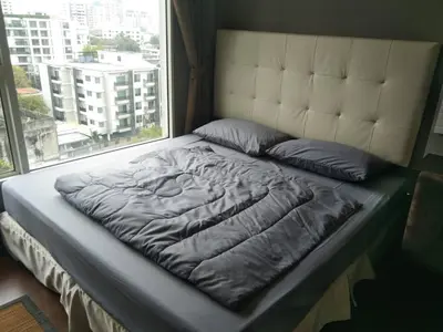 a bed in a room with a large window at Modern Place Watthana, Thonglor BTS, Sukhumvit in Bangkok
