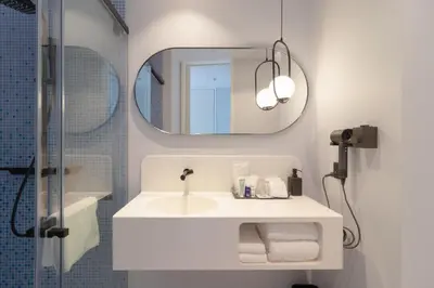 a bathroom with a sink and a mirror at Queensland Hotel Bangkok in Bangkok