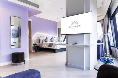a room with a bed and a podium with a screen at Queensland Hotel Bangkok in Bangkok