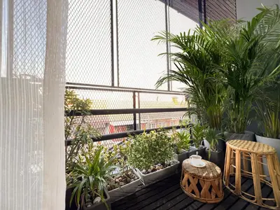 a balcony with plants and a table and chairs at Enjoyo Getaway in Bangkok