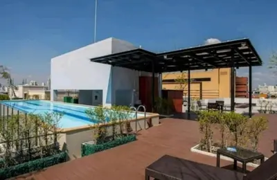 a patio with a swimming pool and a black canopy at 1Br HiSpeed Net, Low rise condo, Near BTS Ekamai in Khlong Toei