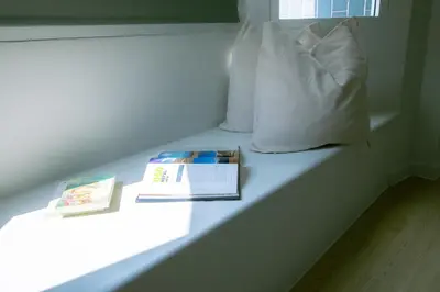 a bench with two books and a pillow at Baan Khun Pra No 1 Bangkok Duplex in Bangkok