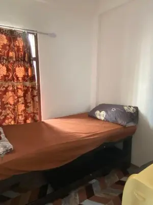a small bed in a room with a curtain at Sleep Break Hostel Sathon in Bangkok