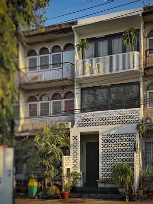 an apartment building with a balcony and plants at Siri Designer 3-Storey Townhouse with Garden and Luxury Amenities in Bangkok