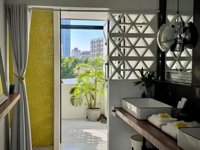 a bathroom with a door leading to a balcony at Siri Designer 3-Storey Townhouse with Garden and Luxury Amenities in Bangkok
