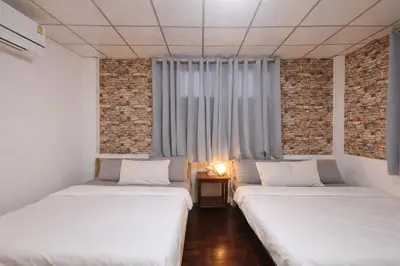 two beds in a room with a window at Sukhumvit 81 Haven House- BTS Onnut in Bangkok