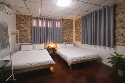 a room with two beds and a table with a plant at Sukhumvit 81 Haven House- BTS Onnut in Bangkok