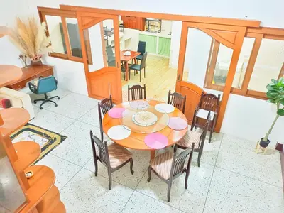 a dining room with a wooden table and chairs at Sukhumvit 81 Haven House- BTS Onnut in Bangkok