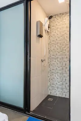 a bathroom with a shower with a glass door at Lachata - Hua Mak in Bangkok