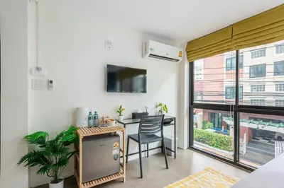 a small kitchen with a table and a dining room at Lachata - Hua Mak in Bangkok