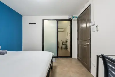 a bedroom with a bed and a sliding glass door at Lachata - Hua Mak in Bangkok
