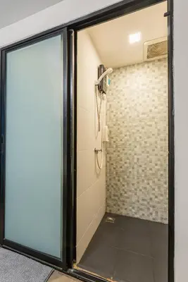 a shower with a glass door in a bathroom at Lachata - Hua Mak in Bangkok