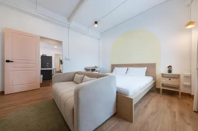 a white bedroom with a bed and a couch at Marshmallow House in Sathani Lak Si