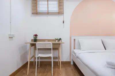 a small table with a chair next to a bed at Marshmallow House in Sathani Lak Si