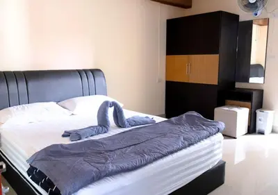 a bed with a stuffed animal on top of it at Cabanaz Pool Villa in Ban Zong Katiam