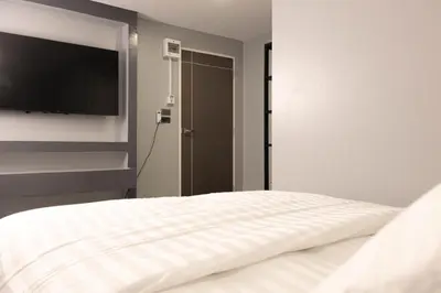 a bedroom with a bed and a flat screen tv at Cabanaz Pool Villa in Ban Zong Katiam