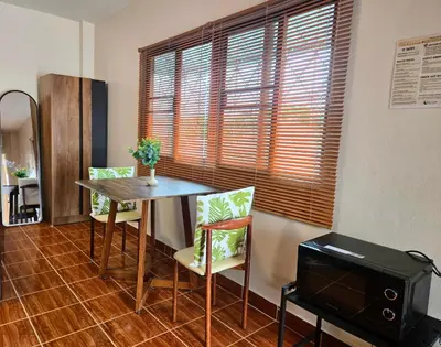 a dining room with a table and chairs and a television at Relax Inn DMK in Lak Si