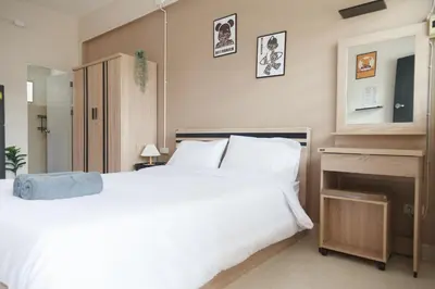 a bedroom with a large white bed and a desk at Relax Inn DMK in Lak Si