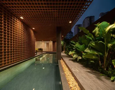 a swimming pool in the middle of a building with plants at Norma Hotel Sathorn in Bangkok