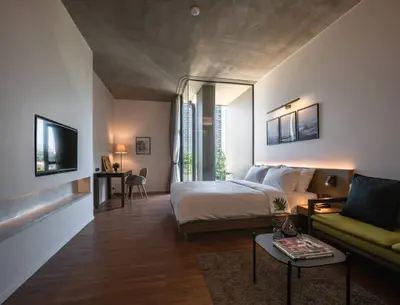 a hotel room with a bed and a couch at Norma Hotel Sathorn in Bangkok