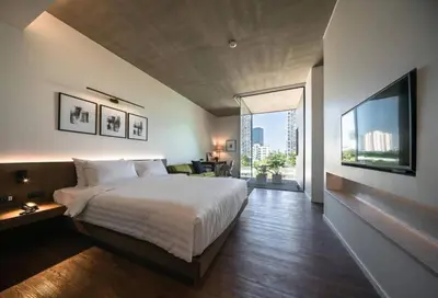 a bedroom with a large bed and a large window at Norma Hotel Sathorn in Bangkok