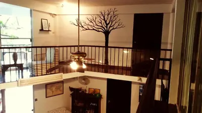 a room with a staircase with a tree on the wall at Home16 Sukhumvit16 in Bangkok