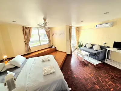 a bedroom with a large bed and a couch at Home16 Sukhumvit16 in Bangkok
