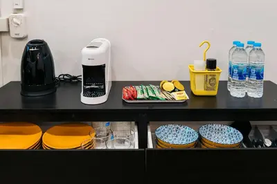 a black counter with plates and cups and bottles of water at Home 18 - Cozy Hideout in Bangkok in Bangkok