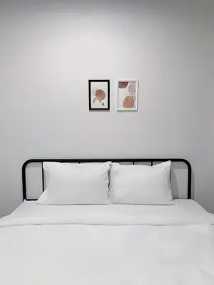 a bed with white sheets and two pictures on the wall at xx BAO The Giant Swing - Sao Chingcha - เบา ศาลเจ้าพ่อเสือ เสาชิงช้า in Bangkok