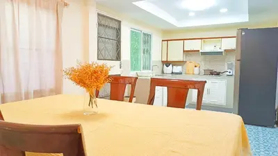 a kitchen with a table with a vase of flowers on it at Retreat House 81 - BTS Onnut in Bangkok