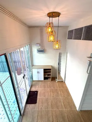 a living room with a chandelier and a floor to ceiling window at DD Canel in Bangkok