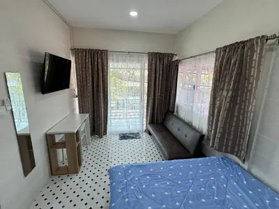 a bedroom with a bed and a desk and window at DD Canel in Bangkok