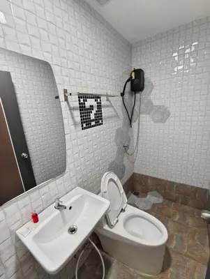 a bathroom with a sink and a toilet and a mirror at Hoft Hotel Ramkhamhaeng24 in Sathani Khlong Tan