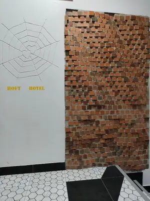 a brick wall next to a wall with a spiderweb at Hoft Hotel Ramkhamhaeng24 in Sathani Khlong Tan