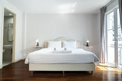 a white bedroom with a white bed and a window at 3 Bedroom Spacious Home in Downtown Bangkok Near MRT BTS Asok Station in Bangkok