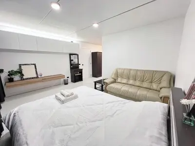 a white bedroom with a bed and a couch at Impact - Donmueng Popular C4 in Ban Song Hong