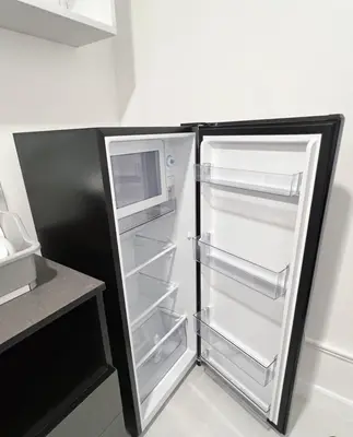 a refrigerator with its door open in a kitchen at Impact - Donmueng Popular C4 in Ban Song Hong