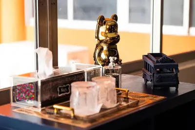 a table with a gold trophy and other items on it at Orange Lodge in Bangkok
